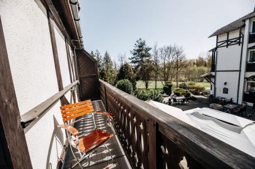 a wooden balcony with a bench on a porch at Schlosshotel Marienbad in Mariánské Lázně