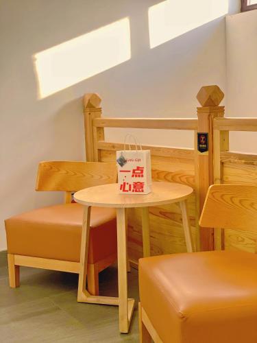 a table and a chair with a bag on it at Elsewhere Hotel Inn Ancient City Center Branch in Pingyao