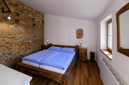 a bedroom with a bed and a brick wall at Penzion Folklór na Gruntě in Mikulčice