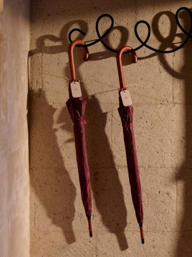 two red umbrellas are hanging on a wall at Argos in Cappadocia in Uchisar