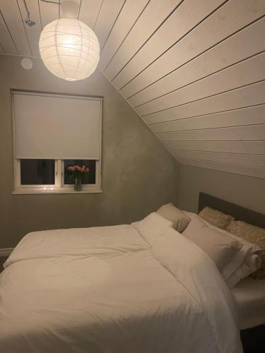 a bedroom with a white bed and a window at Scandinavian Haven in Mörarp
