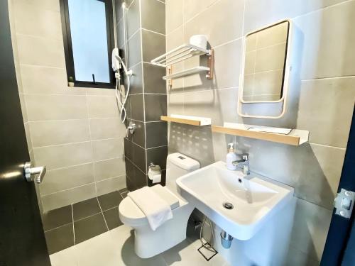 a bathroom with a sink and a toilet and a mirror at Urban Suites George Town in Jelutong