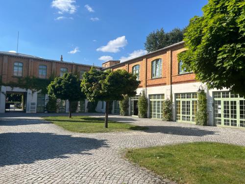 a brick building with trees in front of it at Richter Apartments Finsterwalde 4 in Finsterwalde