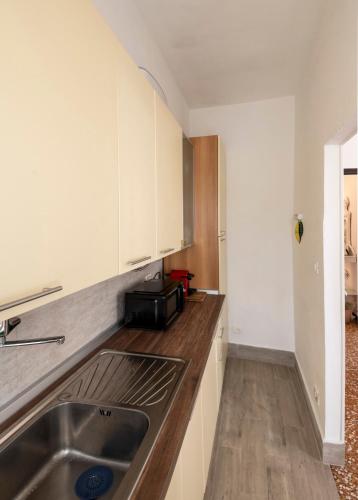 a kitchen with a sink and a microwave at Chiwi's Home in Vado Ligure