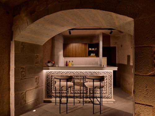 a kitchen with a counter with stools at a bar at Argos in Cappadocia in Uchisar