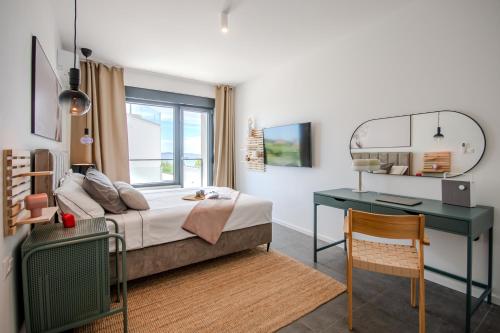 a bedroom with a bed with a desk and a window at Beachfront Villa Taris with Seaview in Privlaka