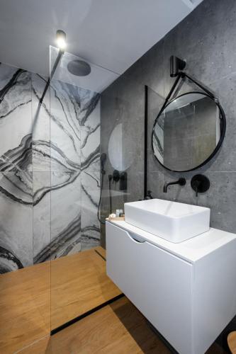 a bathroom with a white sink and a mirror at Beachfront Villa Taris with Seaview in Privlaka