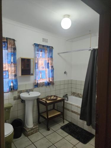 a bathroom with a sink and a toilet and a tub at Cassiandra Place unit 1 in Richards Bay