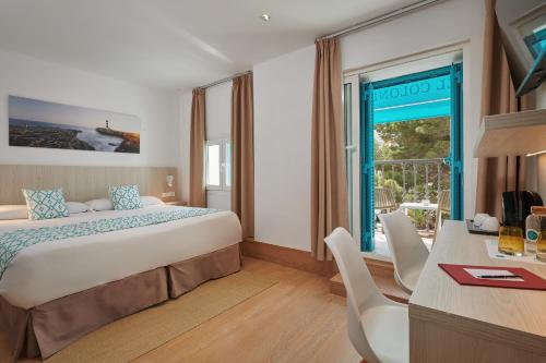 pokój hotelowy z łóżkiem, biurkiem i oknem w obiekcie Hotel Colonial w miejscowości Colonia Sant Jordi