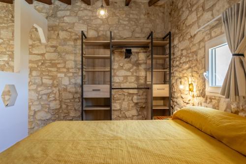 a bedroom with a large bed in a stone wall at Las Casitas Del Mar in Alicante
