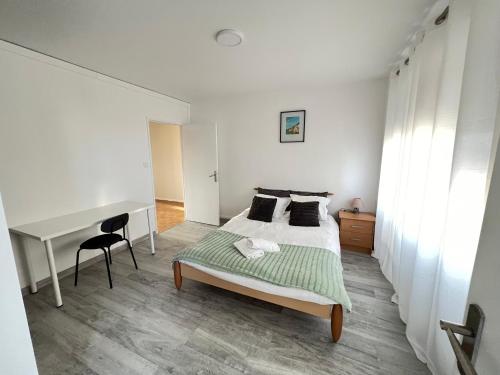 une chambre blanche avec un lit et un bureau dans l'établissement Appartement 3 chambres parking Metz, à Metz