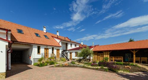 a house with an orange roof and a driveway at Penzion Folklór na Gruntě in Mikulčice