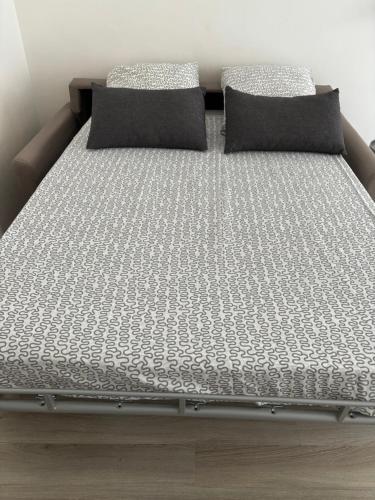 un lit avec deux oreillers dessus dans l'établissement Studio équipé à 9mn à pied du centre ville et de la plage, à Nice