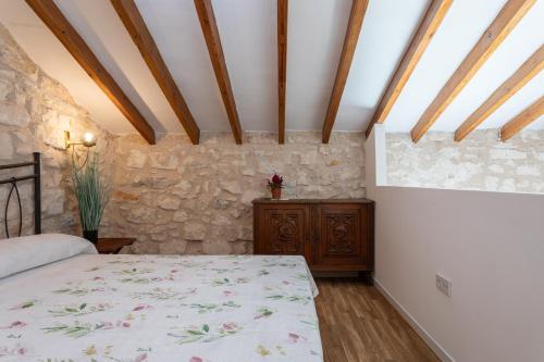a bedroom with a bed and a stone wall at Las Casitas Del Mar in Alicante