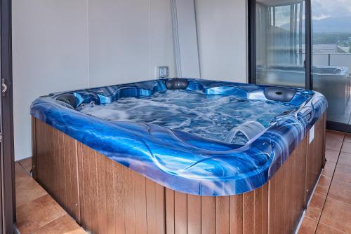 a large hot tub in a room next to a window at Miire Mt Fuji Traditional in Fujikawaguchiko