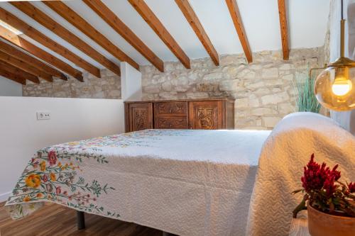 a bedroom with a bed and a stone wall at Las Casitas Del Mar in Alicante