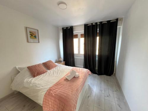 - une chambre avec un lit et une fenêtre avec des rideaux noirs dans l'établissement Appartement 3 chambres parking Metz, à Metz