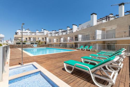 a row of lounge chairs next to a swimming pool at Apartment Andorinha-pretty Holiday Home With Pool in Santa Luzia