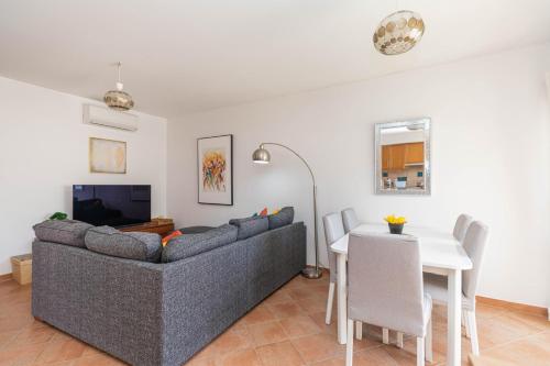 a living room with a couch and a table at Apartment Andorinha-pretty Holiday Home With Pool in Santa Luzia