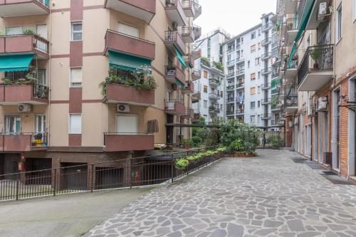 an empty street in a city with tall buildings at Arena 35 in Milan