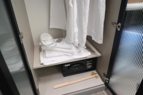 a small closet with towels and a bat on a shelf at Kilim Boutique Hotel in Baku