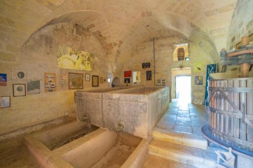 San Donato di LecceMasseria Le Palmentelle Pool And Garden - Happy Rentals的建筑物内有大石浴缸的大房间