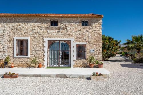 a stone house with a door in a yard at Las Casitas Del Mar in Alicante