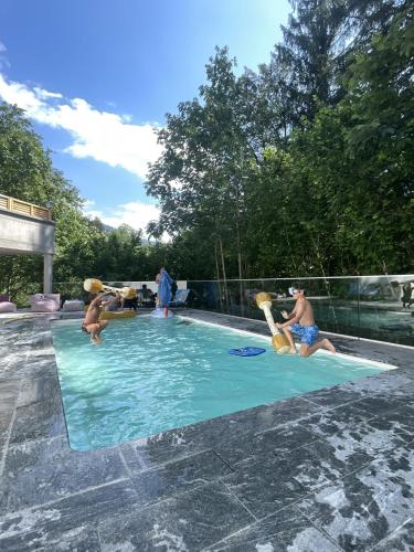 um grupo de pessoas brincando em uma piscina em Hotel Obermayr em Ebenau