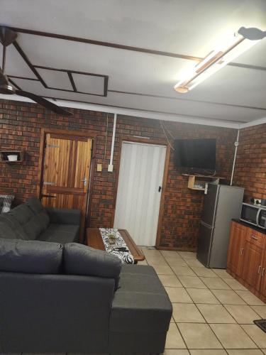 a living room with a couch and a refrigerator at Cassiandra Place unit 2 in Richards Bay