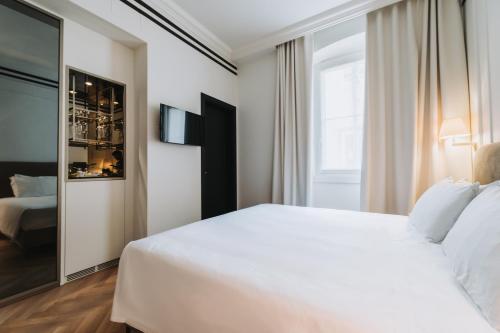 a bedroom with a large white bed and a window at Hotel Continentale in Trieste