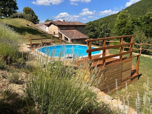 a pool with a wooden fence and a house at La casa del Tiglio in Borgo San Lorenzo