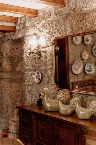 a mirror on top of a dresser in a room at HAGAH Alojamentos - Gerês in Vieira do Minho