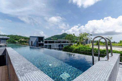 an infinity pool on the roof of a building at Tropics Pool View 2BR Kamala Apartment CTG P605-6, near Beach in Kamala Beach