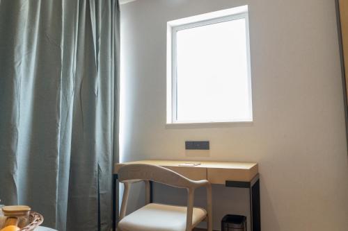 a desk with a chair in a room with a window at Copper Leaf Hotels, Tirunelveli in Tirunelveli