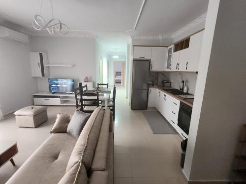 un soggiorno e una cucina con divano e tavolo di Casa Soluna Vlora a Vlorë