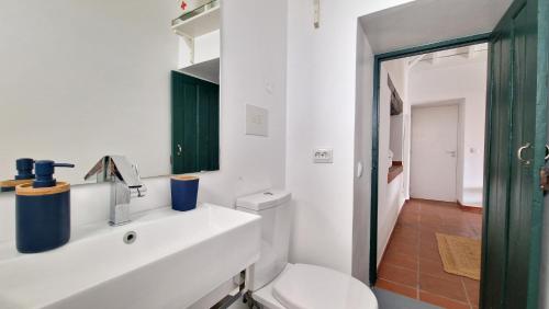 a bathroom with a white sink and a toilet at Nossa Casa by Casas dos Lebre in Porto Santo