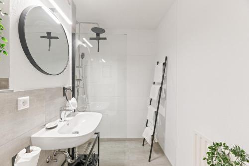 un bagno bianco con lavandino e specchio di Black Forest Design Apartment a Bad Wildbad