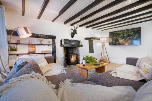 a living room with a couch and a fireplace at The Gilpin Farmhouse, Lake District Getaway in Levens