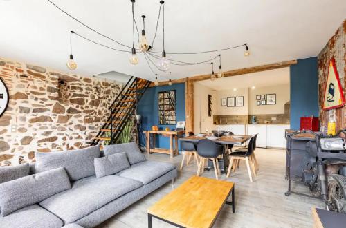 un salon avec un canapé et un mur en pierre dans l'établissement Le Rétro à Kaysersberg, à Kaysersberg