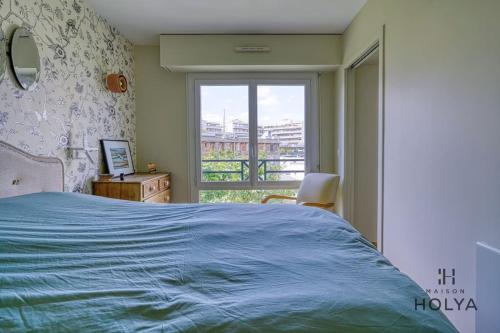 une chambre avec un lit bleu et une fenêtre dans l'établissement Le Rétro - À Bastille - 170C, à Paris