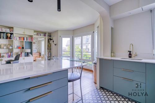 - une cuisine avec des placards bleus et blancs et un évier dans l'établissement Le Rétro - À Bastille - 170C, à Paris