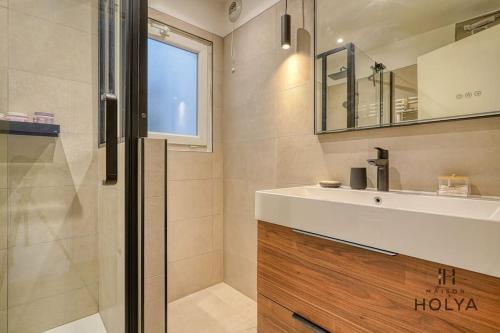 une salle de bain avec un lavabo, un miroir et une douche dans l'établissement Le Rétro - À Bastille - 170C, à Paris