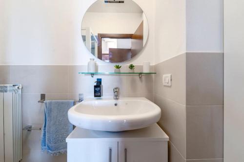 a white bathroom with a sink and a mirror at Certosa House - Milano in Milan