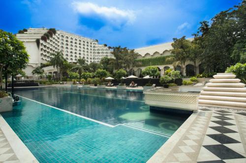 a resort swimming pool with a hotel in the background at Taj Krishna in Hyderabad