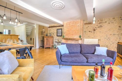 a living room with a purple couch and a table at Gite Authentique, Village Classé in Saint-Jean-de-Côle