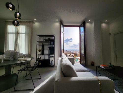 ein Wohnzimmer mit Sofa und Tisch in der Unterkunft Matteotti Royale Apartments in Syrakus