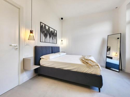 Schlafzimmer mit einem Bett und einem Spiegel in der Unterkunft Matteotti Royale Apartments in Syrakus