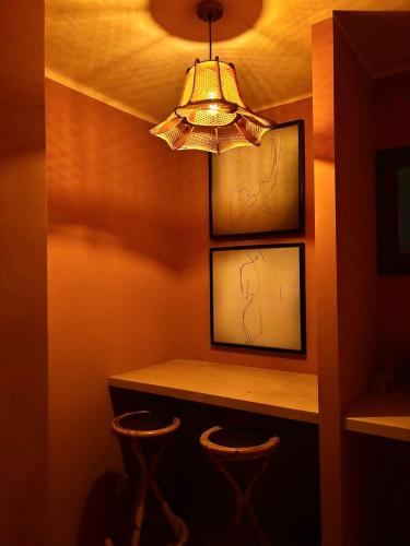 a chandelier in a room with two bar stools at MalaQuita Hotel Boutique in Santa Eularia des Riu