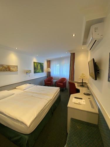 a hotel room with a bed and a desk at Landhaus Alpinia in Berlin