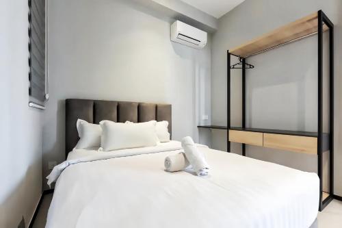 a bedroom with a white bed and a mirror at Urban Suites George Town in Jelutong